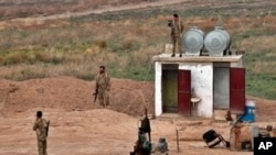 FILE - Fighters from the Syrian Democratic Forces, SDF, stand guard at the Syrian side of the border with Iraq near Rabiaa border crossing, Iraq.