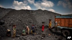 Indian laborers load coal into a truck in Dhanbad, an eastern Indian city in Jharkhand state, Friday, Sept. 24, 2021. (AP Photo/Altaf Qadri)