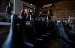 Abraham Rodríguez sews shoes at his shoe shop in Villa Rosasani on the outskirts of La Paz, Bolivia, June 28, 2019. Rodríguez’s small shoe store grew into a factory that employed more than a dozen workers. Now he employs one.