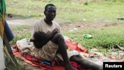 Suspected carrier of Ebola virus James Flomo sits in isolation with his child in Monrovia, Liberia, Jan. 21, 2015. African leaders are due to disucuss Ebola crisis during the summit in Addis Ababa, Ethiopia.