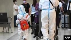 International travelers wearing personal protective equipment arrive at Melbourne's Tullamarine Airport on Nov. 29, 2021, as Australia records it's first cases of the omicron variant of COVID-19.