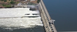 FILE - Water flows through the Dalles Dam, along the Columbia River, in The Dalles, Oregon, June 3, 2011.