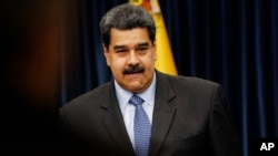 Venezuela's President Nicolas Maduro stands up after a press conference at the Miraflores Presidential Palace, in Caracas, Sept. 18, 2018.