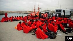 Would-be immigrants rest at Tarifa's harbor after being rescued off the Spanish Coast, Aug. 11, 2014.
