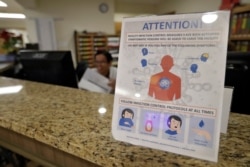 An infection Control Protocol poster sits on a nursing station desk at the Palm Garden of Tampa Health and Rehabilitation Center, March 5, 2020, in Tampa, Fla.