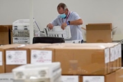 FILE - Arizona election officials count ballots for the general election inside the Maricopa County Recorder's Office, Nov. 6, 2020, in Phoenix.