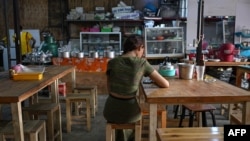 This photo taken on June 4, 2024 shows "Khaing," a former teacher with the Civil Disobedience Movement (CDM), sitting in a restaurant where she works after fleeing from Myanmar to Thailand to avoid conscription by Myanmar's military junta, in Bangkok.