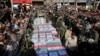 Flag-draped caskets of those who died in Saturday's terror attack on a military parade are laid out during a mass funeral, in the southwestern city of Ahvaz, Iran, Sept. 24, 2018. 