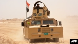 Iraqi government forces drive their armored vehicle, June 22, 2016, some 40 kilometers (25 miles) west of Qayyarah, during their operation to take the city and make it a launchpad for Mosul. 