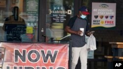 A customer walks past a now hiring sign at an eatery in Richardson, Texas, Sept. 2, 2020. 