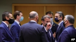 French President Emmanuel Macron, center, speaks with Hungary's Prime Minister Viktor Orban, right, during a round table meeting in Brussels, Dec. 10, 2020, where European Union leaders meet for a year-end summit. 