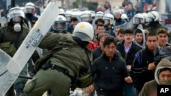 Riot police scuffle with migrants during a protest in Mytilene port on the northeastern Aegean island of Lesbos, Greece, Feb. 4, 2020. 