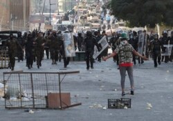FILE - Iraqi anti-riot police try to prevent anti-government protesters from crossing the al-Shuhada (Martyrs) bridge in central Baghdad, Iraq, Nov. 6, 2019.