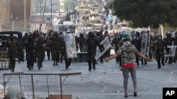 Iraqi anti-riot police try to prevent anti-government protesters from crossing the al- Shuhada (Martyrs) bridge in central Baghdad, Iraq, Nov. 6, 2019. 