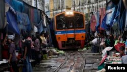 FILE - A Train arrives in Maeklong, in Samut Songkhram province, Thailand.