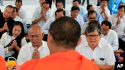 FILE PHOTO- Former Vice President of opposition party Cambodia National Rescue Party Pol Ham, center left, prays together with his former party lawmaker Son Chhay, center right, during a Buddhist ceremony, in Phnom Penh, Cambodia, March 30, 2018. (AP Photo/Heng Sinith)