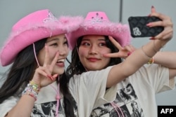 Penggemar penyanyi AS Taylor Swift, juga dikenal sebagai Swifties, berpose di luar Tokyo Dome sesaat sebelum dimulainya "Eras Tour" Asia-Pasifik di Tokyo pada 7 Februari 2024.