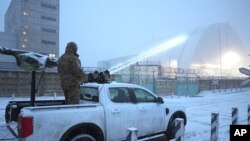 এক সময়কার চেরনোবিল পরমাণু বিদ্যূত্ কেন্দ্রে ড্রোন আক্রমণের পর, ইউক্রেন সামরিক বাহিনীর একজন একটি গাড়িতে বিমান বিধ্বংসী বন্দুক নিয়ে দাঁড়িয়ে আছে। ইউক্রেন, ১৪ ফেব্রুয়ারি,২০২৫। 