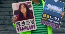 FILE - A pro-democracy activist holds placards with the picture of Chinese citizen journalist Zhang Zhan outside the Chinese central government's liaison office, in Hong Kong, Dec. 28, 2020.