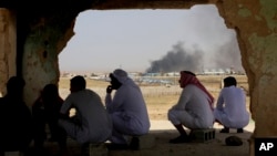 Warga desa Jabir, Yordania mengamati pemberian bantuan bagi ribuan pengungsi Suriah di dekat perbatasan Yorrdania. 