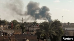 Smoke rises from the site of a suicide car bomb attack at a used cars dealers parking in Hayy al-Shurta, neighborhood in southern Baghdad, Iraq, Feb, 16, 2017.