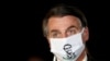 Brazil's President Jair Bolsonaro speaks with journalists while wearing a protective face mask as he arrives at Alvorada Palace, amid the coronavirus disease outbreak, in Brasilia, May 22, 2020. 
