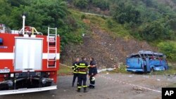 In this handout photo provided by the Bulgarian Interior Ministry, firefighters near the scene where a bus crashed and overturned, near the town of Svoge, Aug. 25, 2018.