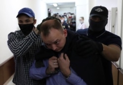 FILE - Ivan Safronov, a former journalist who works as an aide to the head of Russia's space agency Roscosmos, is detained on suspicion of treason and escorted before a court hearing in Moscow, Russia, July 7, 2020.
