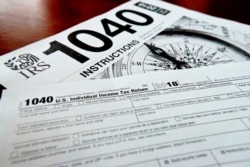 FILE - Multiple forms printed from the Internal Revenue Service web page are used for 2018 U.S. federal tax returns, in Zelienople, Pennsylvania, February 13, 2019.