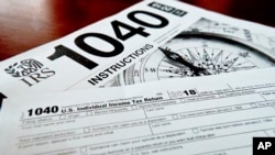 FILE- This Feb. 13, 2019, photo shows multiple forms printed from the Internal Revenue Service web page that are used for 2018 U.S. federal tax returns, in Zelienople, Pennsylvania.