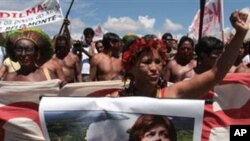 A member of the Kaiapo tribe holds a poster showing a picture of Brazilian President Dilma Rousseff during a protest against the construction of Belo Monte hydroelectric dam in Brasilia, Brazil, Tuesday Feb. 8, 2011.