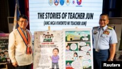 2025年1月24日，菲律賓海岸警衛隊南中國海事務發言人傑伊·塔里拉(Jay Tarriela 右)與菲律賓國家安全顧問愛德華多·阿諾（Eduardo Ano 左）在馬尼拉的菲律賓國家圖書館舉行的漫畫書《胡恩老師說故事》新書發表會上。