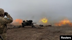 Service members of the 92nd Separate Mechanized Brigade of the Ukrainian Armed Forces hold artillery drills at a shooting range in an unknown location in eastern Ukraine, in this handout picture released December 17, 2021. 