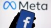 A smartphone with Facebook's logo is seen in front of displayed Facebook's new rebrand logo Meta in this illustration taken Oct. 28, 2021. 