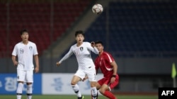 A handout photo taken Oct. 15, 2019, by the Korea Football Association (KFA) shows players fighting for the ball during a World Cup 2022 qualifying match between South Korea and North Korea at Kim Il Sung Stadium in Pyongyang.