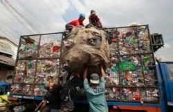 Workers load collected plastic bottles on to a truck at a junk shop in Manila, March 10, 2015. The Philippines placed third among the list of countries with the most ocean plastic pollution per year.