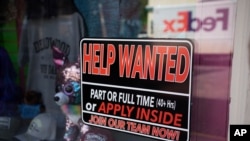 A sign for workers hangs in the window of a shop along Main Street in Deadwood, S.D. U.S. employers added 559,000 jobs in May, an improvement from April’s sluggish gain, May 26, 2021.