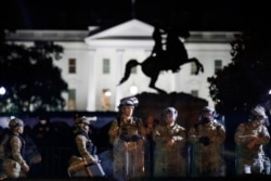 A line of DC National Guard members stand in Lafayette Park as demonstrators gather to protest the death of George Floyd, June 2, 2020, near the White House in Washington.