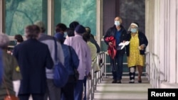 FILE - People line up to cast their ballot for the upcoming presidential election as early voting begins in New Orleans, Louisiana, October 16, 2020.