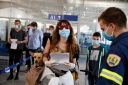 A firefighter directs passengers who arrived from Rome, Italy to the Eleftherios Venizelos International Airport in Athens, June 15, 2020.