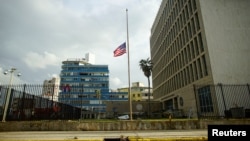 The U.S. flag is lowered to half mast in front of a damaged fence of the U.S. embassy after Hurricane Irma caused flooding and a blackout, in Havana, Cuba, Sept. 11, 2017. 