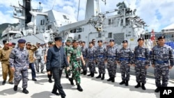 FILE - Indonesian President Joko Widodo, center, inspect troops during his visit at Indonesian Navy ship KRI Usman Harun at Selat Lampa Port, Natuna Islands, Indonesia, Wednesday, Jan. 8, 2020. 