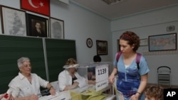 A Turkish woman prepares to cast her vote at a polling station in Ankara, Turkey, June 12, 2011