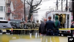 Police officers gather nearby the scene following reports of gunfire, in Jersey City, N.J., Dec. 10, 2019.