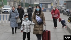 People walk on a street in Beijing on Jan. 17, 2024. China's population decline accelerated in 2023, official data showed, extending a downward streak after more than six decades of growth as the country battles a looming demographic crisis. 