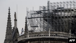 Para pekerja mulai memperbaiki Gereja Kaedral Notre-Dame di Paris, Perancis, 23 April 2019.
