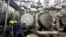 FILE - Workers try to tie a pipe at an oil refinery in Port Harcourt, Nigeria, Sept. 16, 2015. One of two state refineries in Port Harcourt will resume refining of crude oil in early August 2024, officials say.