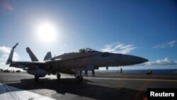 FILE - A F/A 18E Super Hornet on the deck of the aircraft carrier USS Ronald Reagan, July 6, 2010.