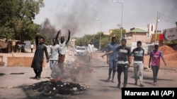 Des gens brûlent des pneus lors d'une manifestation le lendemain de la prise du pouvoir par l'armée à Khartoum au Soudan, le 26 octobre 2021. 