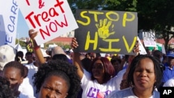 FILE - Activists march in Durban, South Africa, July 18, 2016, at the start of the 21st World Aids Conference. A new clinical trial is underway in South Africa on an experimental vaccine that could safely prevent HIV, the virus that causes AIDS.